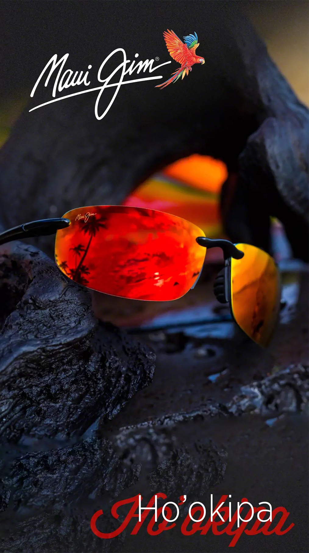 Randlose Sonnenbrille mit roten Spiegelgläsern mit Maui Jim leigt auf Lavagestein