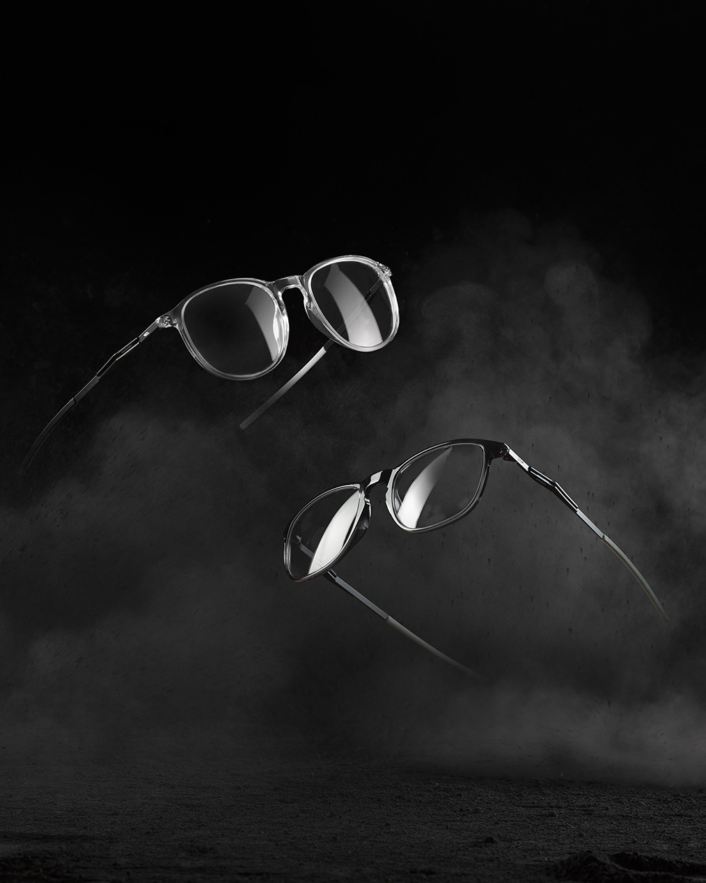 Zwei Brillenmodelle mit schwarzem und durchsichtigem Gestell vor dunklem Hintergrund