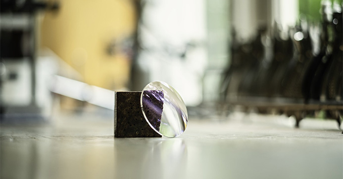 Brillenglas von Hoya liegt angelehnt an einem Stück Granit