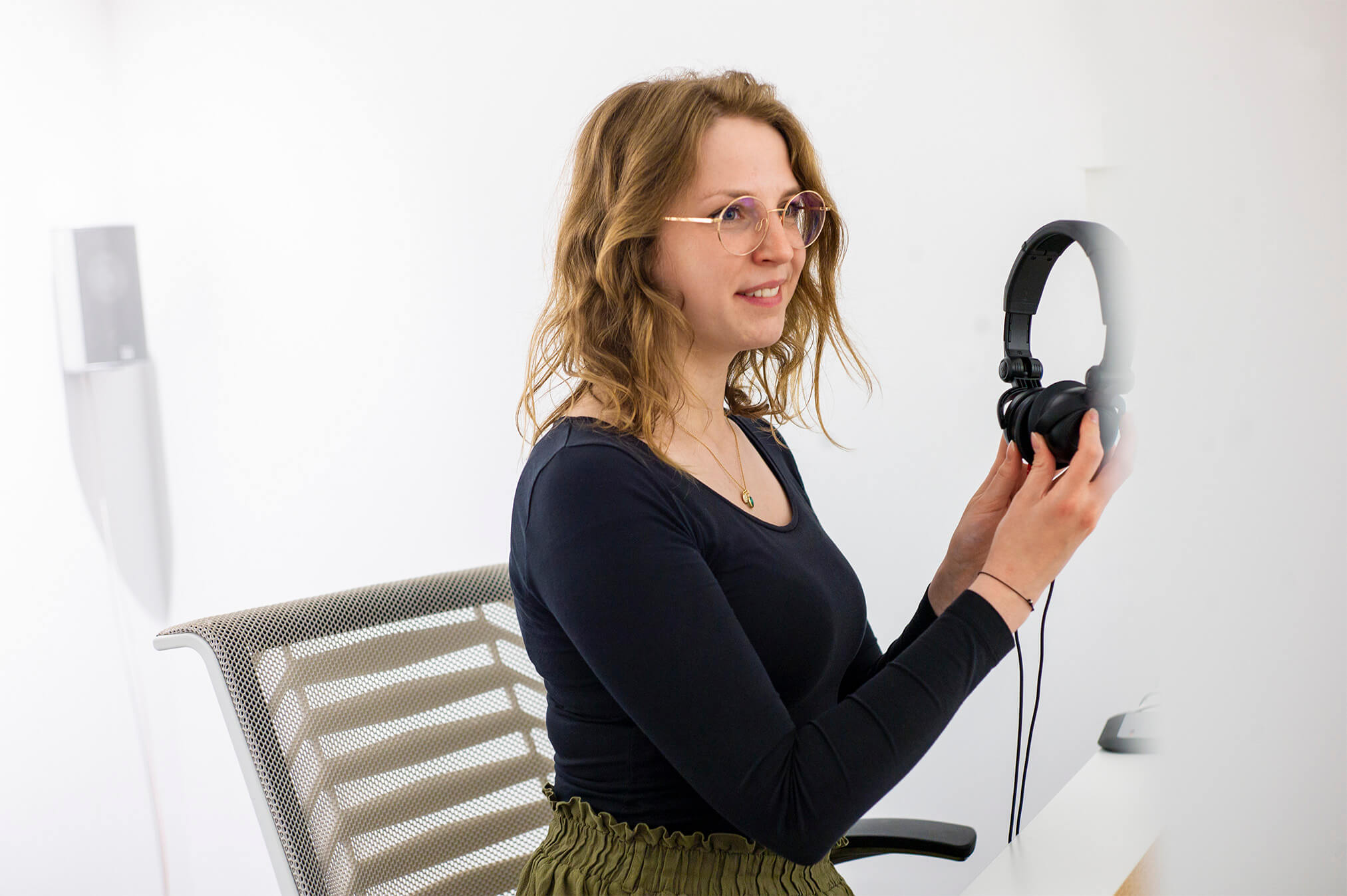 Junge Frau setzt sich gerade die Kopfhörer für den Hörtest auf