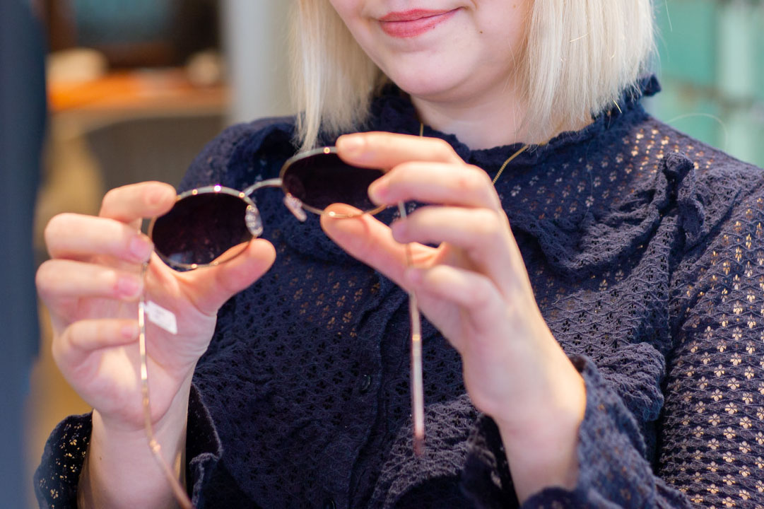 Mitarbeiterin hält ein Sonnenbrillengestell in ihren Händen