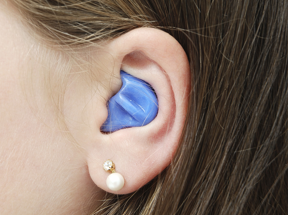 Nahaufnahme eines Ohrs mit exakt passendem Gehörschutz in der Ohrmuschel