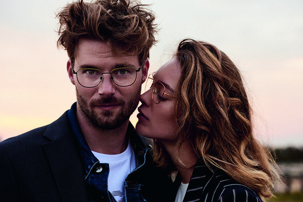 Junges Paar mit Mexx Brillen stehen in der Dämmerung