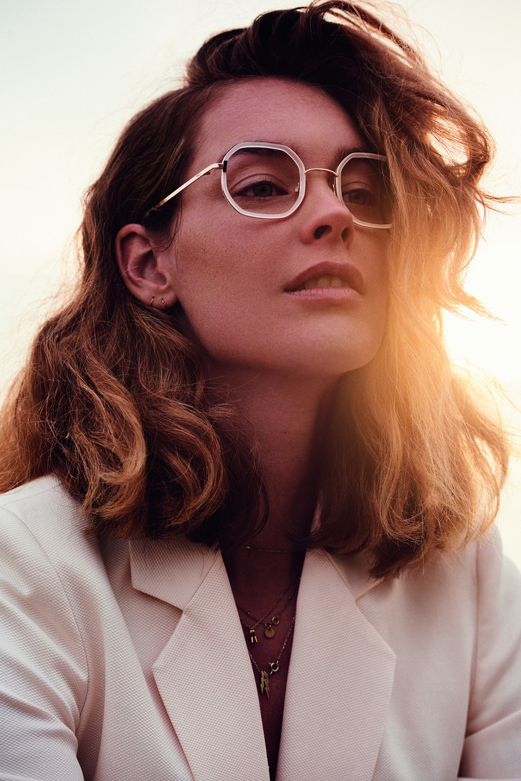 Junge Frau mit silberner Brille von Mexx wird von hinten von der Sonne angeleuchtet