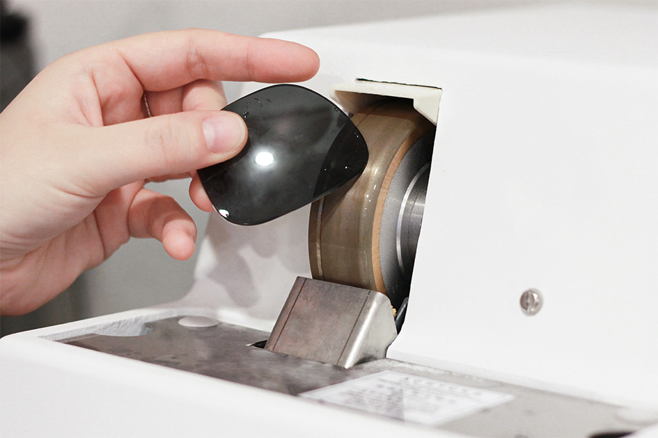 Sonnebrillenglas wird an der Schleifmaschine bearbeitet
